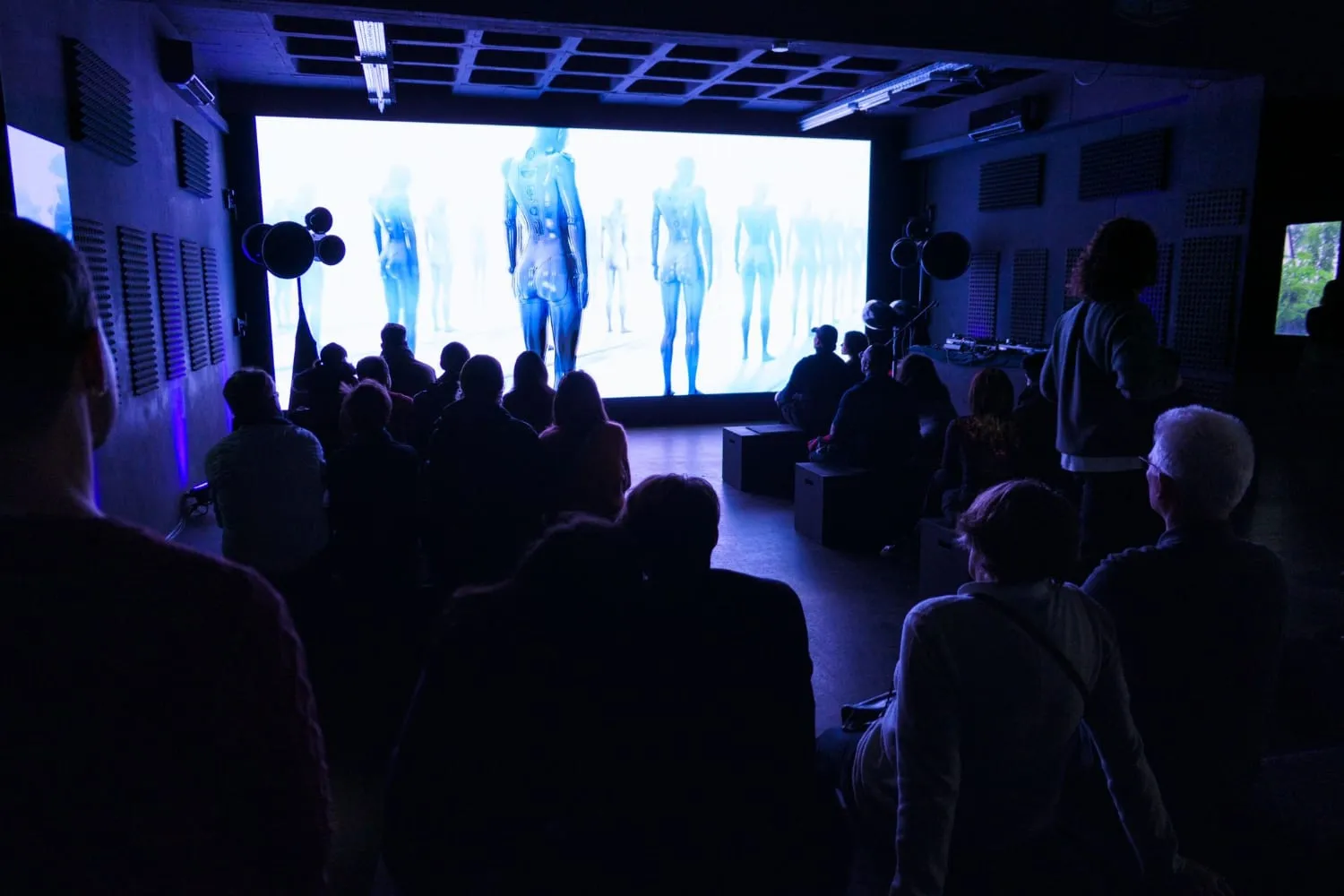 P61 Gallery — Publikum vor einer großflächigen digitalen Projektion